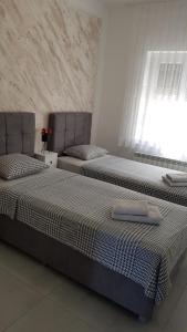 two beds sitting next to each other in a bedroom at Kabashi Apartment in Krk