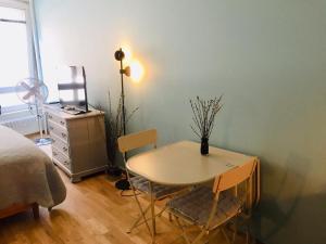 a room with a table and chairs and a bed at Rue Jean-Antoine Gautier in Geneva