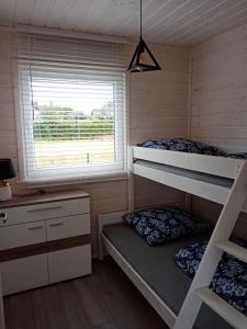 a bedroom with two bunk beds and a window at Domki na górce in Kołczewo +36 photos