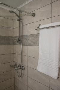 a shower with a white towel on a wall at De La Plage Hotel Koroni in Koroni