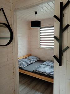 two beds in a sauna with a window at Domki na górce in Kołczewo