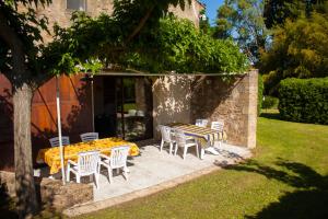 a patio with a table and chairs in a yard at Maison d'Hôtes Lou Geneste in Bollène