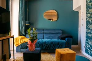 - un salon bleu avec un canapé et un miroir dans l'établissement coeur de ville t2, terrasse, clim tt équipe, parking, à Sanary-sur-Mer