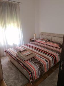 - un lit avec une couverture rayée et une fenêtre dans l'établissement Marina, à Budva