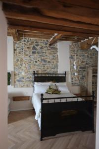 sypialnia z czarnym łóżkiem i kamienną ścianą w obiekcie B&B La Taccola w mieście Castelnuovo di Val di Cecina