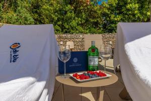 un tavolo con un piatto di frutta e bicchieri da vino di Apartment Di Blu a Novi Vinodolski