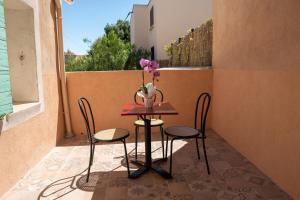 a table with two chairs and a vase with flowers on a balcony at coeur de ville t2, terrasse, clim tt équipe, parking in Sanary-sur-Mer