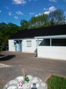 a white house with a driveway with a building at kleines gemütliches Ferienhaus in Poseritz