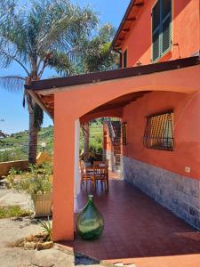 een oranje huis met een vaas op een patio bij La casa del Podere in Castellaro