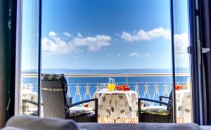Villa Lenka and Mate Ivanac في بريلا: طاولة وكراسي على شرفة مطلة على المحيط