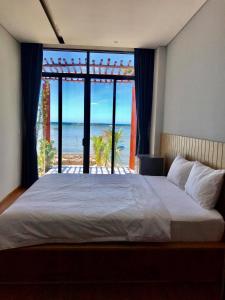 1 dormitorio con 1 cama y vistas al océano en Aurora Beach House, en Phu Quoc
