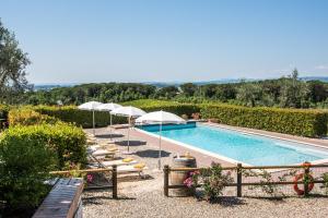 a swimming pool with umbrellas and lounge chairs next to it at Agriturismo Amina, Winery & Hiking in Vagliagli