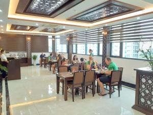 een groep mensen die aan tafel zitten in een restaurant bij T&M Luxury Hotel Hanoi in Hanoi