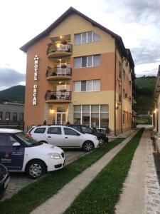 um edifício com carros estacionados em frente em Hotel-Restaurant Oscar em Piatra Neamţ