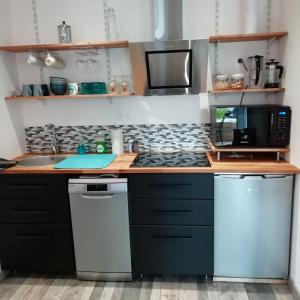 a kitchen with black cabinets and a counter top at La Petite Pause in Verlinghem +4 photos