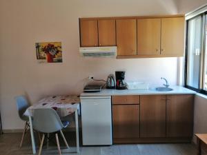 a small kitchen with a table and a sink at Jason Rooms & Studios in Keratokampos