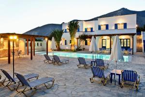 a resort with a table and chairs and a pool at Villa Clio in Perissa