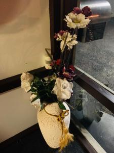 Anna Bella Motel Glen Innes في غلين اينيس: مزهرية مليئة بالورود تجلس أمام المرآة