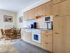 uma cozinha com um fogão, um micro-ondas e uma mesa em Marie_3 em Heringsdorf