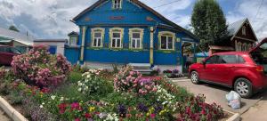 
a blue car parked in front of a house at Gostevoy Dom Zakharovykh in Suzdal
