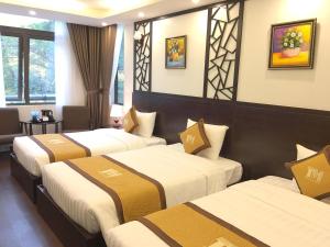 een hotelkamer met drie bedden bij T&M Luxury Hotel Hanoi in Hanoi