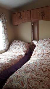 2 letti posti uno accanto all'altro in una camera da letto di Caravan 6 Berth North Shore Holiday Centre with 5G Wifi a Winthorpe