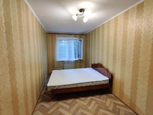 a small room with a bed with a window at Filatov apartment in Odesa