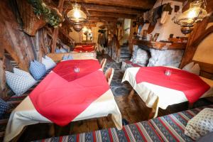 2 Tische mit roten Sonnenschirmen in einem Zimmer in der Unterkunft Pension Garni Hochmoos in Lermoos