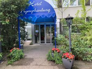 un edificio con un tendone blu con fiori e una luce di strada di Hotel Nymphenburg City - München a Monaco