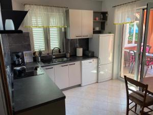 a kitchen with white cabinets and a black counter top at Apartman ENA in Opatija