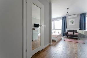 a living room with a large mirror and a couch at Apartament Alfa with free parking in Poznań