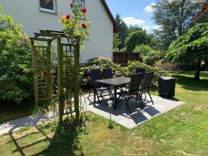 a table and chairs in a garden with a gazebo at Heidewohnung in Soltau