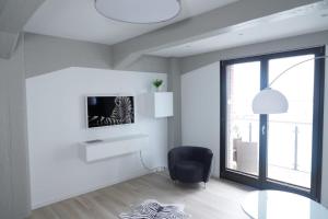 un soggiorno bianco con tavolo in vetro e sedia di Speicher Residenz Barth E2 App 1 a Barth
