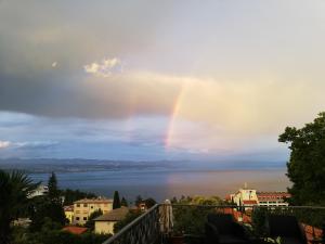 um arco-íris no céu sobre um corpo de água em Villa Allegra em Lovran