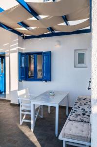 a table and chairs in a room with blue cabinets at APOLLON by Akroploro in Pollonia