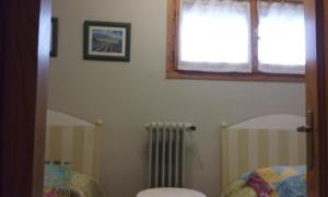a bathroom with a toilet and a window and a radiator at apartamento Valles Blancos 3-6 in Biescas +1 photo