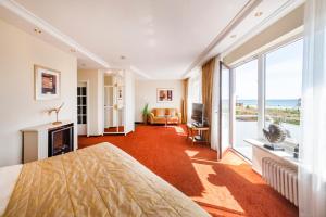 1 dormitorio con cama y vistas al océano en Hotel Apartments Büngers - Mein Refugium am Meer mit Sommerstrandkorb, en Strande