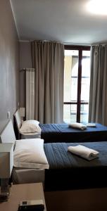 ein Hotelzimmer mit 2 Betten und einem Fenster in der Unterkunft Central Park in Casarile