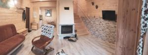 a living room with a couch and a television at DOMKI STROME ZACISZE in Niedzica Zamek