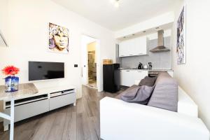 Il comprend un salon blanc avec un canapé blanc et une cuisine. dans l'établissement Affori Cosy Apartment, à Milan