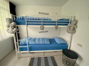 a bedroom with three bunk beds with blue and white pillows at Ferienresidenz Seegarten -Andrea App1 - beheizter Indoor-Pool in Bodman-Ludwigshafen