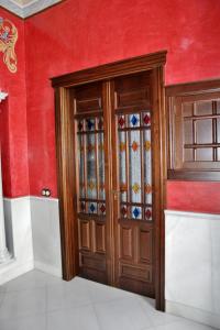 a wooden door with stained glass in a red wall at El Zaguán de la Plata in Fuente de Cantos