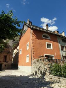 Saint-Dalmas-le-SelvageにあるLa maison basseの石壁のオレンジ白住宅
