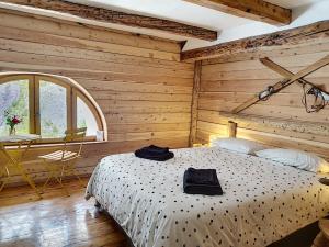 Saint-Dalmas-le-SelvageにあるLa maison basseの木製の部屋にベッド1台が備わるベッドルーム1室があります。