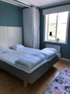 Un dormitorio con una cama con paredes azules y una ventana en Grindhuset, en Söderköping