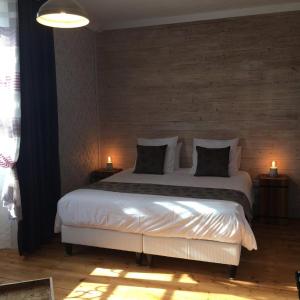 a bedroom with a large white bed with two lamps at Tilleuls et Bambous in Saint-Sauveur-dʼAunis