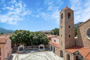 a church with a clock tower in a town at La casa di Minnanna in Cannigione