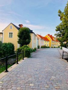 una strada di ciottoli con case e panchina di Grindhuset a Söderköping