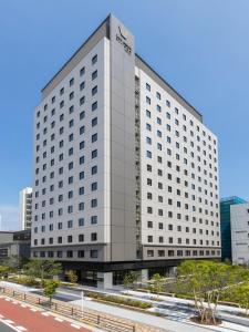 Far East Village Hotel Tokyo Ariake في طوكيو: مبنى ابيض كبير عليه لافته