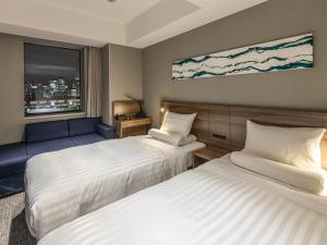 ein Hotelzimmer mit zwei Betten und einem Fenster in der Unterkunft Far East Village Hotel Tokyo Ariake in Tokio